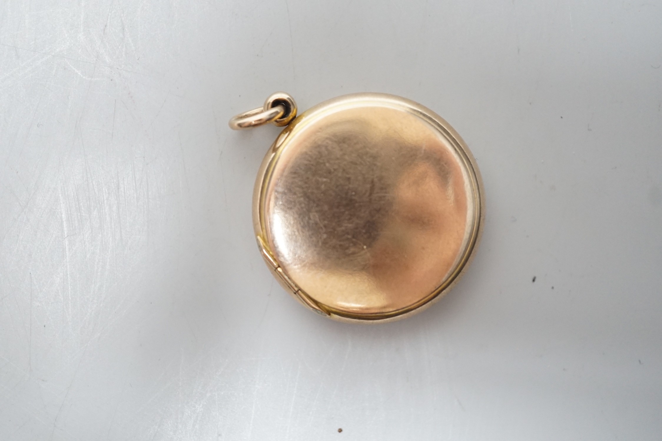 A 9ct gold mounted circular triptych locket, diameter 29mm, gross weight 10.8 grams.